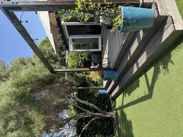 Private green garden beside the sunny raised patio
