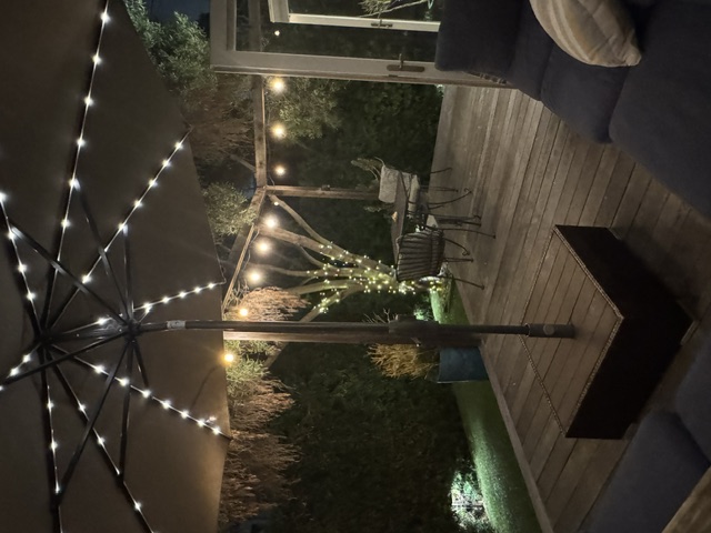 Cozy patio seating beneath a lighted umbrella at night
